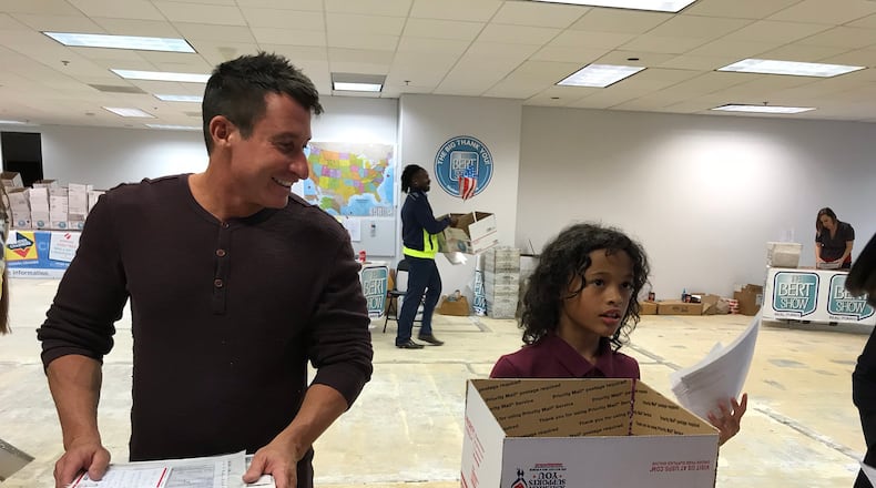 Bert Weiss kibitzes with Athena, a young volunteer. CREDIT: Rodney Ho/rho@ajc.com