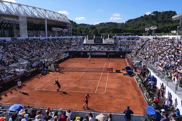 People watch a training session between Italy's Lorenzo Sonego, serving bottom, and Italy's Jannik Sinner at the Foro Italico in Rome, Italy, May 6, 2025 (Alfredo Falcone/LaPresse via AP)