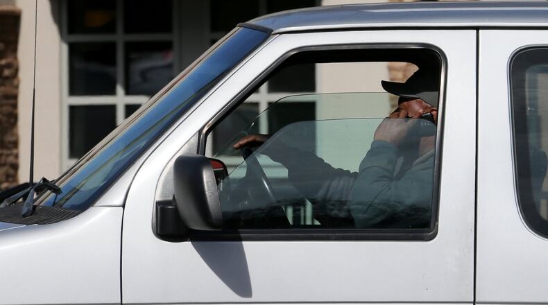 A man talks on his cellphone while driving down Northside Parkway in Atlanta. (BOB ANDRES / bandres@ajc.com / January 2015 AJC file photo)
