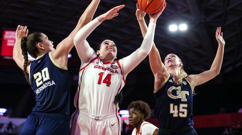 Georgia center Jenna Staiti (14) shoots the ball defended by Georgia Tech center Nerea Hermosa (20) and forward Digna Strautmane (45) during the first half of an NCAA basketball game on Sunday, Dec. 5, 2021 in Athens, Ga. (AP Photo/Gary McCullough)