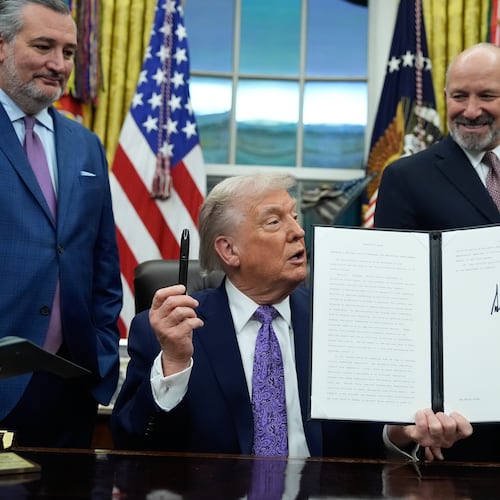 Flanked by Sen. Ted Cruz R-Texas, left, and Secretary of Commerce Howard Lutnick, President Donald Trump displays his signed AI initiative in the Oval Office of the White House, Thursday, Dec. 11, 2025, in Washington. (AP Photo/Alex Brandon)