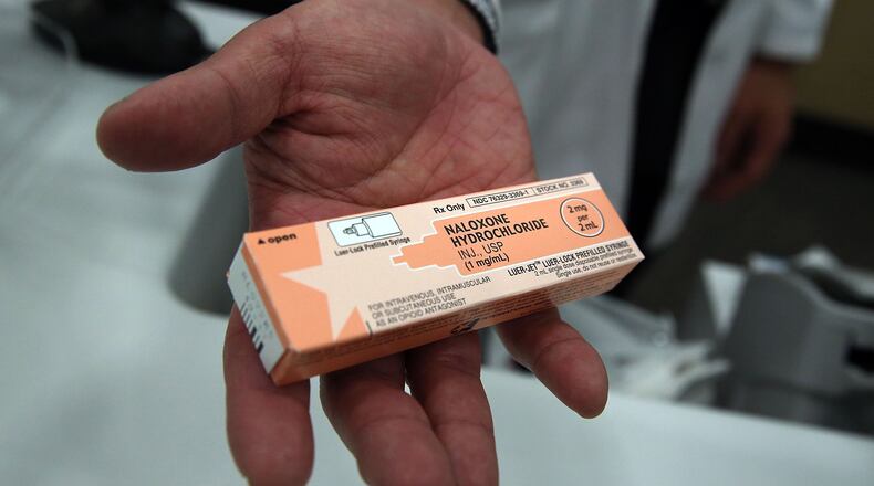 A pharmacist at a Walgreens store holds a box of the overdose antidote Naloxone Hydrochloride.