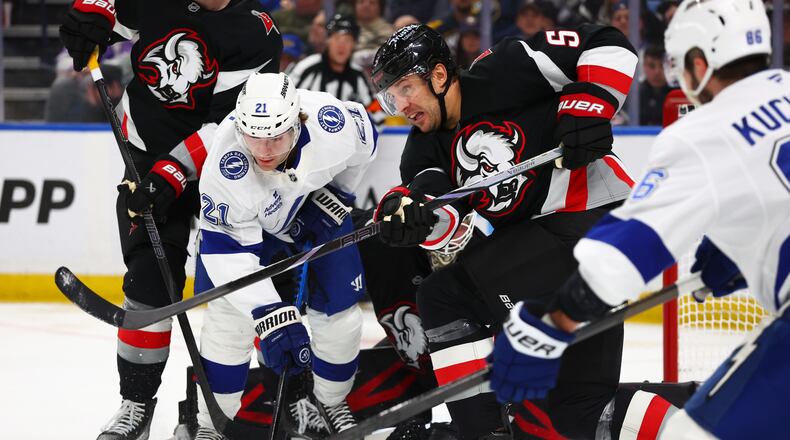 Buffalo Sabres defenseman Luke Schenn (5) clears the puck in front of Tampa Bay Lightning center Brayden Point (21) during the second period of an NHL hockey game Monday, April 6, 2026, in Buffalo, N.Y. (AP Photo/Jeffrey T. Barnes)