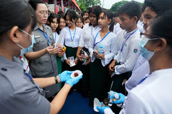 Police officers explain illegal narcotics to students during a destruction ceremony to mark International Day against Drug Abuse and Illicit Trafficking, on the outskirts of Yangon, Myanmar, Thursday, June 26, 2025. (AP Photo/Thein Zaw)