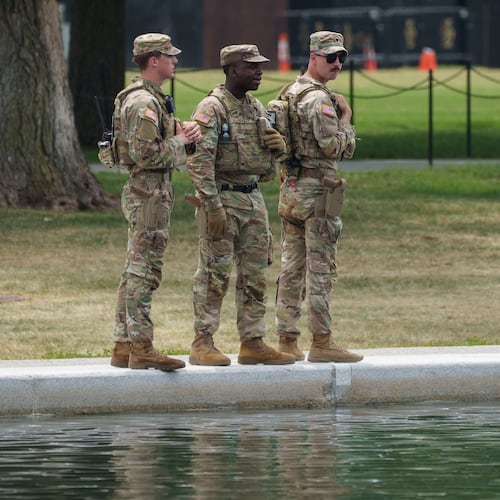 Members of the National Guard stop and look at the Lincoln Memorial Reflecting Pool Sunday, June 21, 2026, on the National Mall in Washington. (AP Photo/Jon Elswick