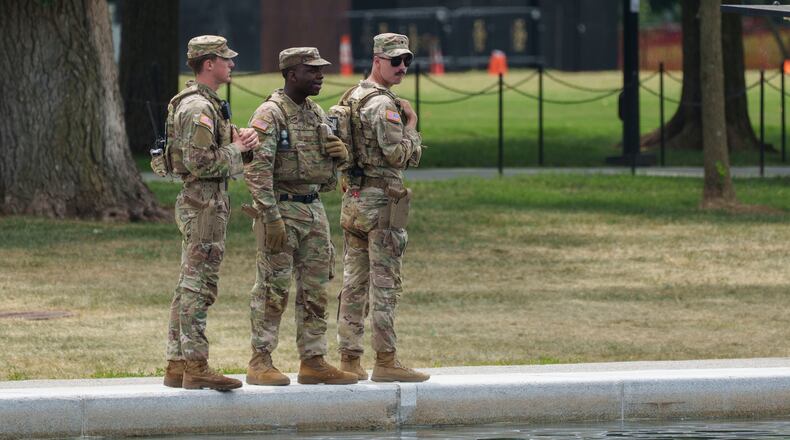 Members of the National Guard stop and look at the Lincoln Memorial Reflecting Pool Sunday, June 21, 2026, on the National Mall in Washington. (AP Photo/Jon Elswick