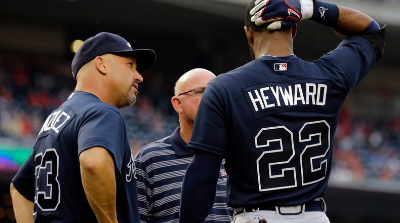 Atlanta Braves manager Fredi Gonzalez, left, and trainer Jeff Porter look over Atlanta Braves' Jason Heyward during the first inning of a baseball game against the Washington Nationals at Nationals Park on Aug. 6, 2013, in Washington. Heyward continued his at bat, but left the game afterwards. He is day-to-day.