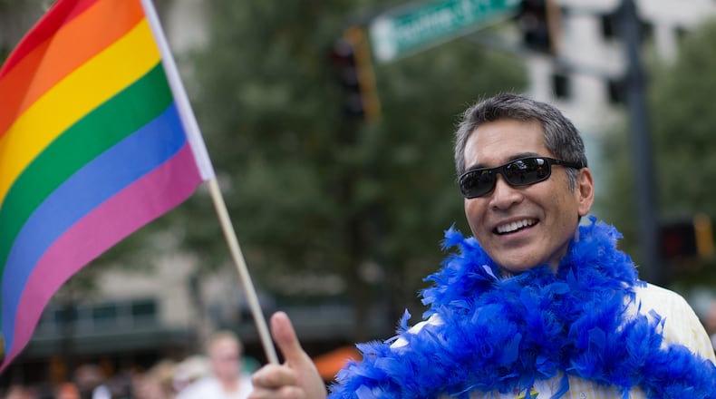 Former Atlanta City Councilman Alex Wan marches down Peachtree Street during the 2015 Atlanta Pride Parade. Wan has recently discovered that men are using his image to “catfish” Asian women around the world. BRANDEN CAMP/SPECIAL