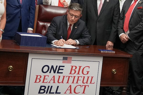 Speaker of the House Mike Johnson, R-La., center, surrounded by fellow Republicans, signs President Donald Trump's signature bill of tax breaks and spending cuts, Thursday, July 3, 2025, at the Capitol in Washington. (AP Photo/Mariam Zuhaib)