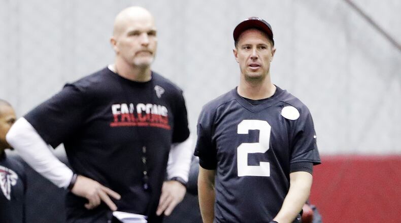 Atlanta Falcons quarterback Matt Ryan walks on the field near head coach Dan Quinn during a workout at the team's practice facility in Flowery Branch Friday, Jan. 27, 2017.