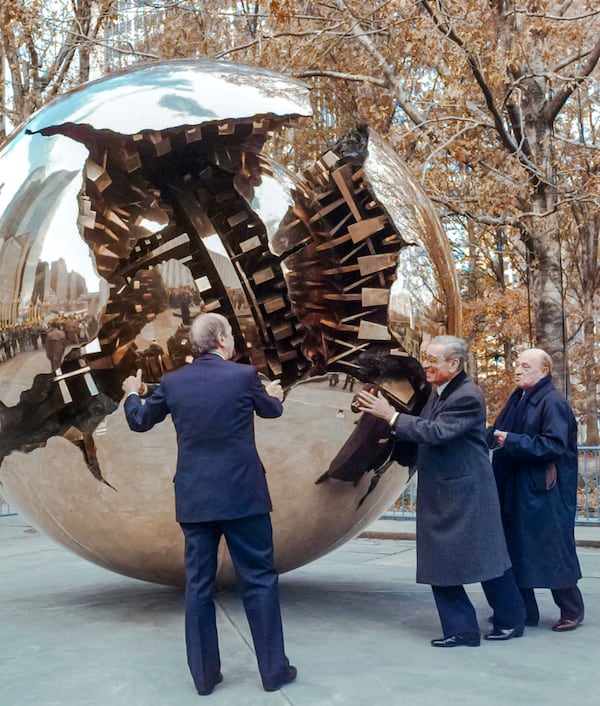 FILE-- Boutros Boutros-Ghali, center, secretary general of the United Nations, gives a push to Italian sculptor Arnaldo Pomodoro's, right, "Sphere Within a Sphere" during its unveiling at the United Nations, Thursday, Nov. 21, 1996. Helping him to rotate the 8-ton bronze sculpture is Italy's Foreign Minister Umberto Dini, left. (AP Photo/Mark Lennihan)