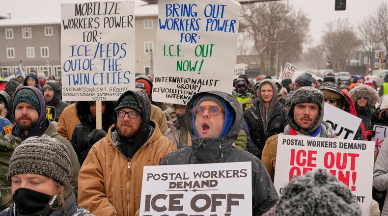 People march and gather near the post office during a protest, Sunday, Jan. 18, 2026, in Minneapolis. (AP Photo/Yuki Iwamura)