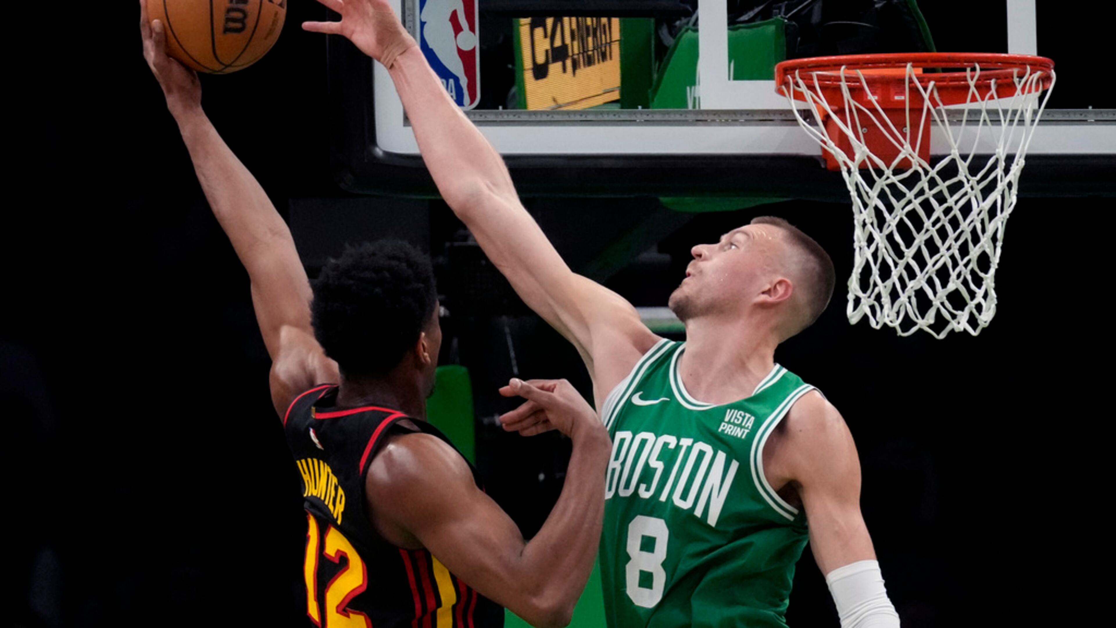 Boston Celtics center Kristaps Porzingis reaches to block a shot by Atlanta Hawks forward De'Andre Hunter during the first half of an NBA basketball game Wednesday, Feb. 7, 2024, in Boston. (Charles Krupa/AP)