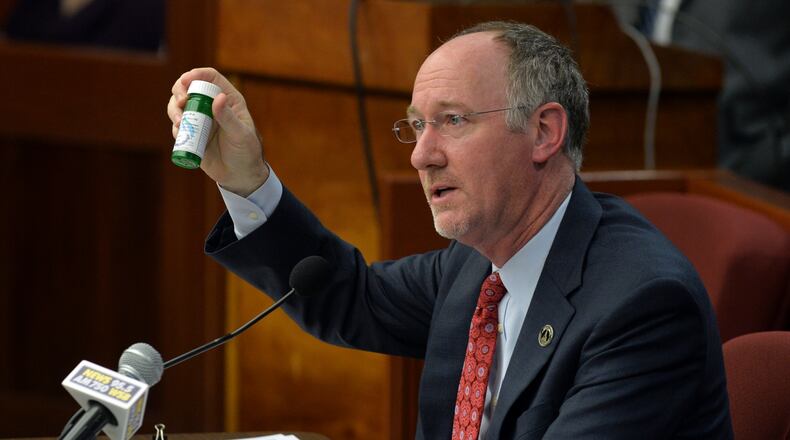 Georgia State Rep. Allen Peake, R-Macon shows a bottle of medical cannabis oil as he presents his House Bill 1 on Feb. 3, 2015. BRANT SANDERLIN / BSANDERLIN@AJC.COM