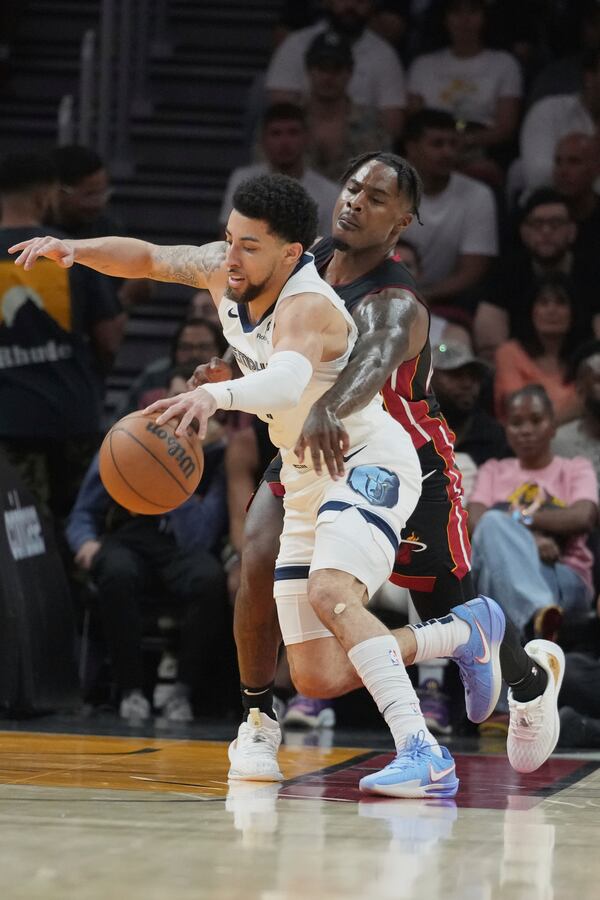 Miami Heat guard Davion Mitchell (45) defends Memphis Grizzlies guard Scotty Pippen Jr. (1) during the first half of an NBA basketball game, Thursday, April 3, 2025, in Miami. (AP Photo/Marta Lavandier)