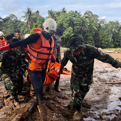 Rescuers carry the body of a flood victim, in Agam, West Sumatra, Indonesia, Sunday, Nov. 30, 2025. (AP Photo/Ade Yuandha)