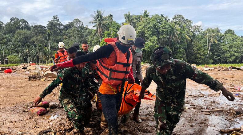 Rescuers carry the body of a flood victim, in Agam, West Sumatra, Indonesia, Sunday, Nov. 30, 2025. (AP Photo/Ade Yuandha)