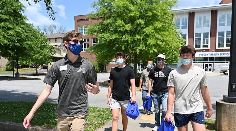 Tour guide John Hovell (left) leads potential students and a parent on a tour of the University of North Georgia's Dahlonega campus on Wednesday, April 28, 2021. (Hyosub Shin / Hyosub.Shin@ajc.com)