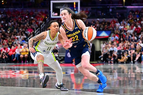Indiana Fever's Caitlin Clark (22) goes to the basket against Dallas Wings' JJ Quinerly (11) during the second half of a WNBA basketball game, Sunday, July 13, 2025, in Indianapolis. (AP Photo/Doug McSchooler)