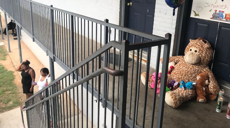 Stuffed animals, balloons and candles adorned the outside of the apartment where Lamora Williams lived with her children.