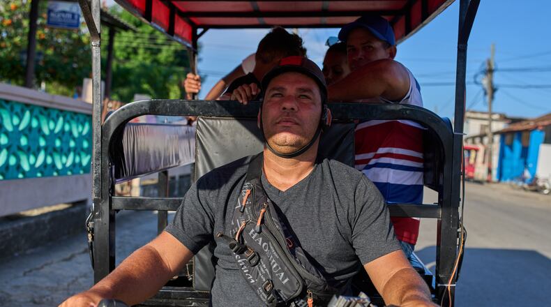 Liexer De La Cruz drives his tricycle with customers in Minas, Cuba's Havana province, Friday, Sept. 4, 2026. (AP Photo/Ramon Espinosa)