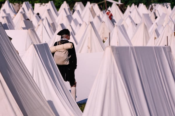 Ed Knight, of Manchester, Vt., who portrays a Colonial soldier, stands among the encampment tents during a reenactment in celebration of the 250th anniversary of the Battle of Bunker Hill, Saturday, June 21, 2025, in Gloucester, Mass. (AP Photo/Charles Krupa)