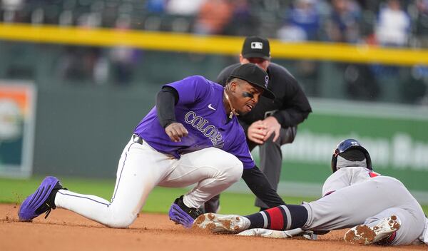 Colorado Rockies second baseman Adael Amador,front left, applies a late tag as Atlanta Braves' Michael Harris II, right, steals second in the fourth inning of a baseball game Monday, April 28, 2025, in Denver. (AP Photo/David Zalubowski)