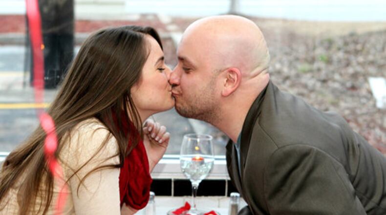 NO WAFFLING ON THIS KISS--Nicole Kovacs & Dominick Racano share a kiss at the Waffle House at Cheshire Bridge road location in Atlanta where customers got an opportunity to have a very special Valentines dinner on Wednesday Feb 14, 2012. Sixty-eight reservations were made for a special tablecloth & candlelight dinner at the famous fast food eatery. This is fifth year the Waffle House location has offered the Valentines celebration featuring a special menu along with the regular items.
