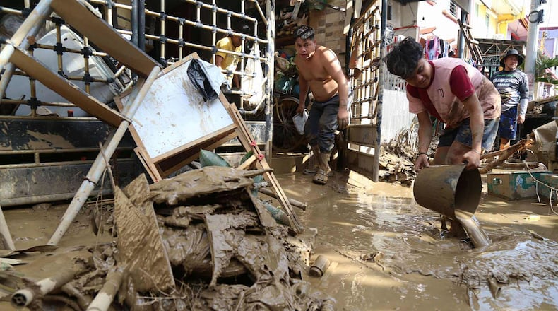 Residents clean up outside their homes after Typhoon Kalmaegi caused devastation in communities at Talisay City, Cebu province, central Philippines, Wednesday, Nov. 5, 2025. (AP Photo/Jacqueline Hernandez)