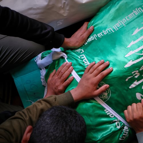 Palestinians place their hands on the body of Izz al-Din al-Haddad, the leader of Hamas' Qassam Brigades, draped in a Hamas flag during his funeral in Gaza City, Saturday, May 16, 2026. (AP Photo/Jehad Alshrafi)