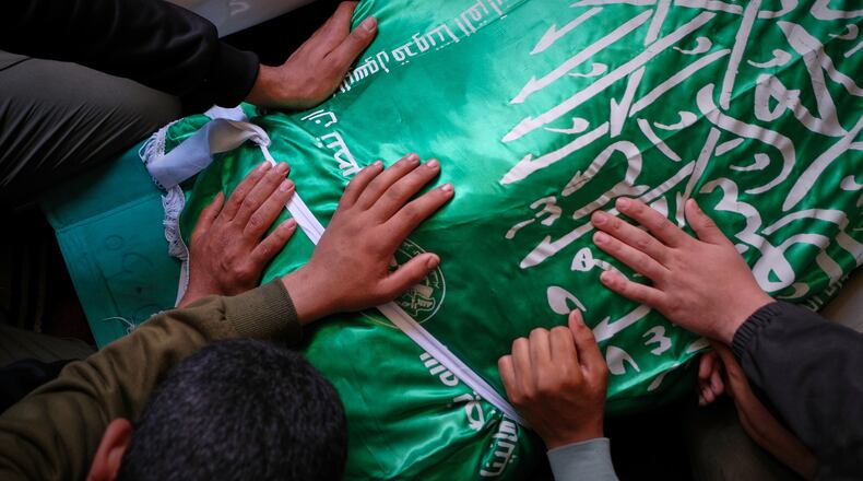 Palestinians place their hands on the body of Izz al-Din al-Haddad, the leader of Hamas' Qassam Brigades, draped in a Hamas flag during his funeral in Gaza City, Saturday, May 16, 2026. (AP Photo/Jehad Alshrafi)