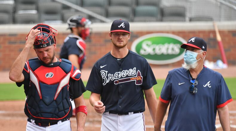 Pitcher Mike Soroka (center) talks with catcher Tyler Flowers (left) and pitching coach Rick Kranitz during a Braves workout at Truist Park. Soroka is scheduled to start for one group of Braves in an intrasquad game Monday.