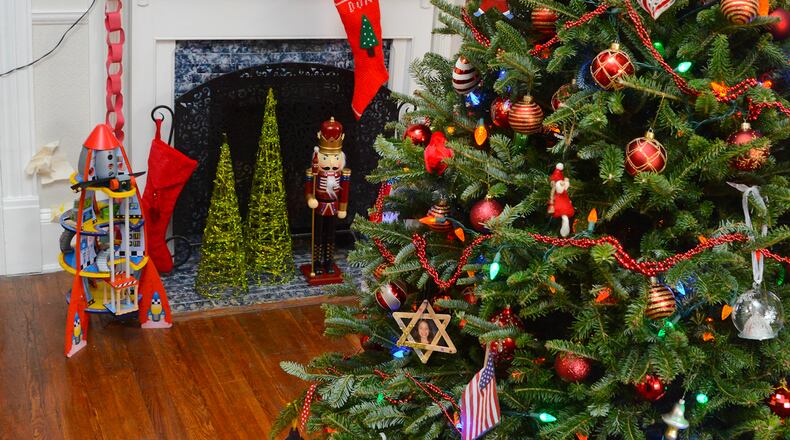 In Rowan and Chloe Richards-Boeff's playroom, mom Meg decorated a 6-foot Christmas tree in red and green with peppermint and homemade ornaments. A train runs around the foot of the tree, while a Santa hat acts as the tree topper.