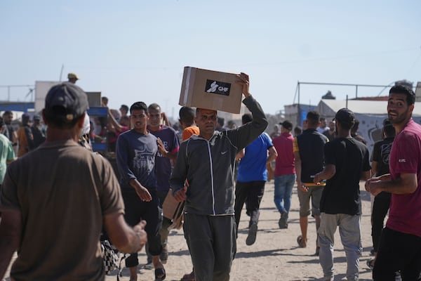 Palestinians carry boxes containing food and humanitarian aid packages delivered by the Gaza Humanitarian Foundation, a U.S.-backed organization approved by Israel, in Rafah, southern Gaza Strip, on Tuesday, May 27, 2025. (AP Photo/Abdel Kareem Hana)
