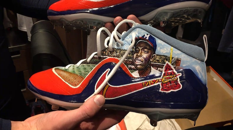 Braves pitcher Sean Newcomb holds one of the custom-made Nike cleats he'll wear in Saturday's start against Colorado. An artist from his college did the work. (Photo by Kevin McAlpin/Braves radio)
