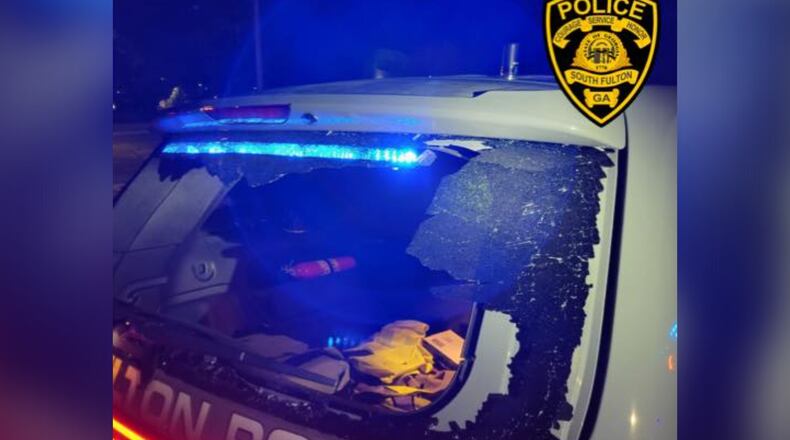 A South Fulton police vehicle was vandalized while the officer was inside during an illegal street racing gathering, authorities said.