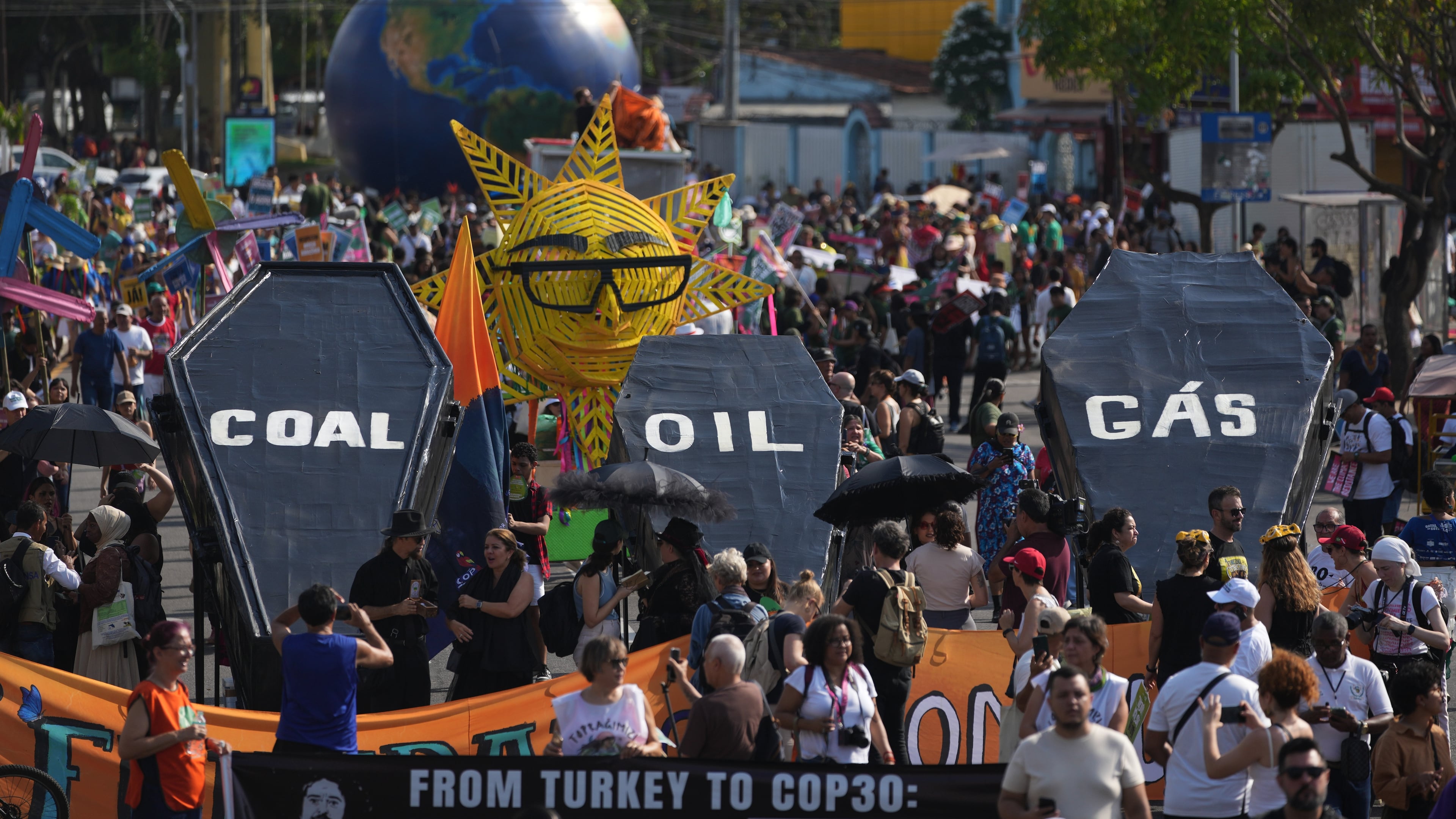 Climate activists protest with coffins that read coal, oil and gas during the COP30 U.N. Climate Summit, Saturday, Nov. 15, 2025, in Belem, Brazil. (AP Photo/Andre Penner)