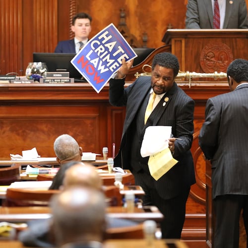 Democratic South Carolina Rep. Wendell Gillard walks back to his desk with a sign after giving a speech during the redistricting debate on Tuesday. May 19, 2026, in Columbia, S.C. (AP Photo/Jeffrey Collins)