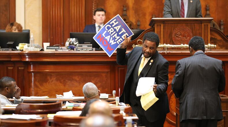Democratic South Carolina Rep. Wendell Gillard walks back to his desk with a sign after giving a speech during the redistricting debate on Tuesday. May 19, 2026, in Columbia, S.C. (AP Photo/Jeffrey Collins)