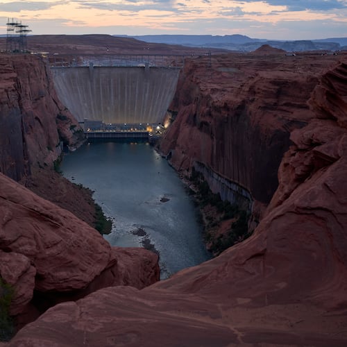 The Colorado River flows beneath the Glen Canyon Dam at the Glen Canyon National Recreation Area, Tuesday, July 14, 2026, near Page, Nev. (AP Photo/John Locher)
