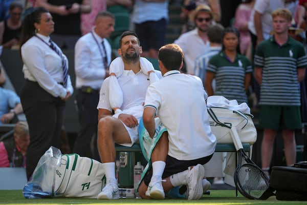 Serbia's Novak Djokovic gets treatment during a medical timeout break against Italy's Jannik Sinner in a men's singles semifinal at the Wimbledon Tennis Championships in London, Friday, July 11, 2025. (AP Photo/Kin Cheung)