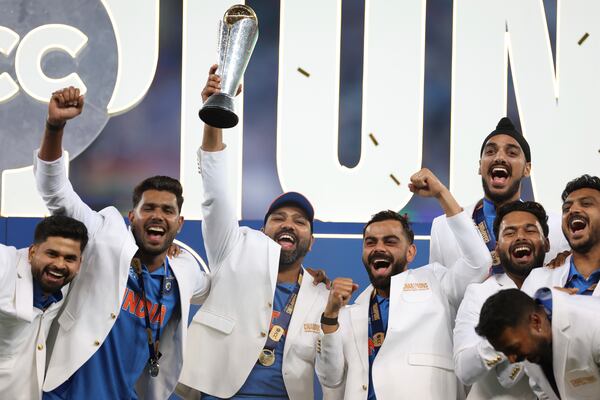 India's captain Rohit Sharma, third left, and teammates celebrate with the winners trophy on the podium after defeating New Zealand in the final cricket match of the ICC Champions Trophy at Dubai International Cricket Stadium in Dubai, United Arab Emirates, Sunday, March 9, 2025. (AP Photo/Christopher Pike)