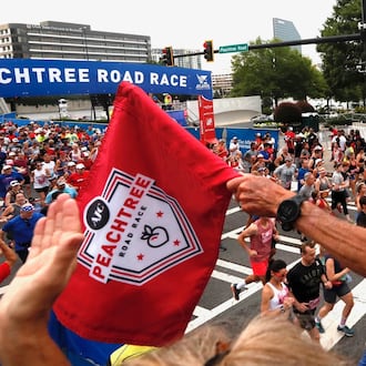 Original Peachtree Road Race winner Jeff Galloway starts and cheers a group of runners at the beginning of the AJC Peachtree Road Race on Thursday, July 4, 2019. (Bob Andres/AJC)