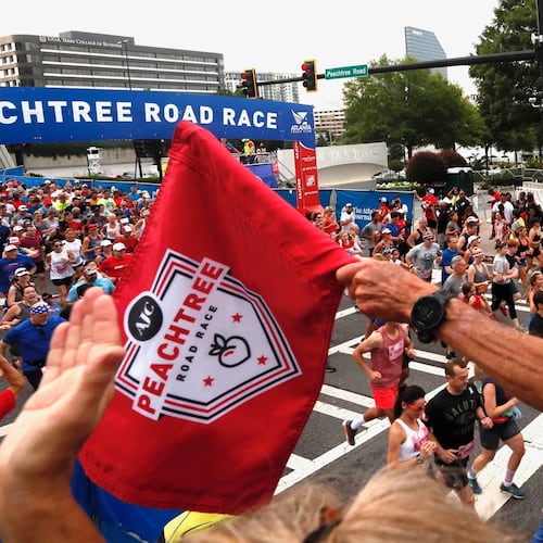 Original Peachtree Road Race winner Jeff Galloway starts and cheers a group of runners at the beginning of the AJC Peachtree Road Race on Thursday, July 4, 2019. (Bob Andres/AJC)