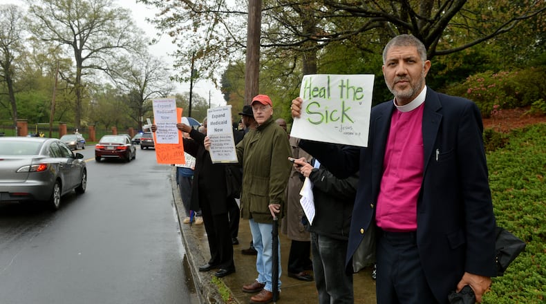 Episcopal Bishop Rob Wright joined with approximately 75 protesters, including several Atlanta clergy members, in a Medicaid expansion rally outside the Governor's Mansion on W. Paces Ferry Road Monday, April 7, 2014. Protesters were calling on Gov. Nathan Deal to expand Medicaid services in the state. KENT D. JOHNSON / KDJOHNSON@AJC.COM