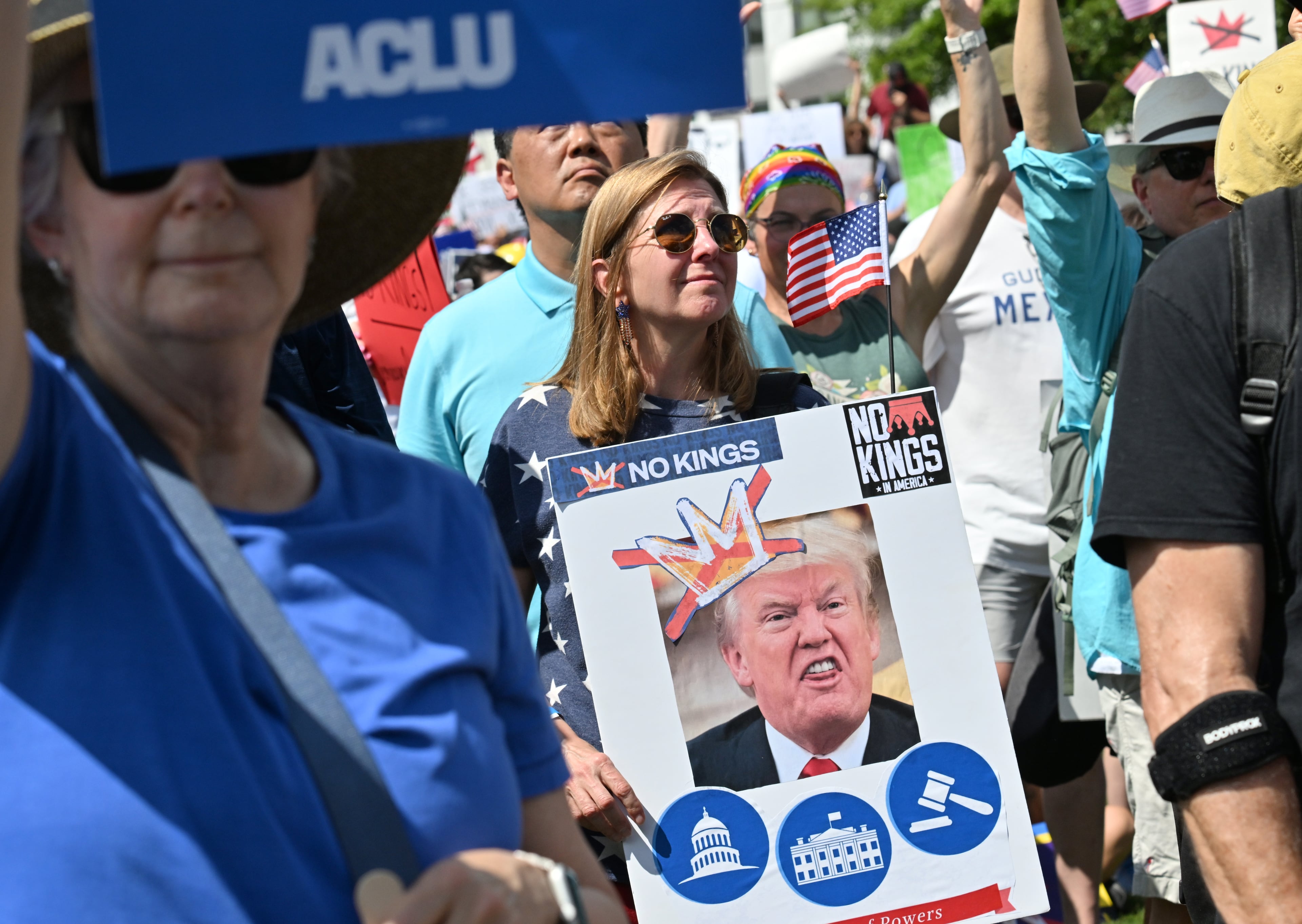 Demonstrators hold signs at Liberty Plaza, near the Georgia Capitol, for a "No Kings" protest to oppose Trump’s immigration policies, Saturday, June 14, 2025, in Atlanta. (Hyosub Shin / AJC)