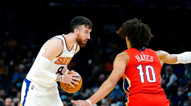 Phoenix Suns forward Frank Kaminsky (8) pauses with the ball as New Orleans Pelicans center Jaxson Hayes (10) defends during the first half of an NBA basketball game Tuesday, Nov. 2, 2021, in Phoenix. (AP Photo/Ross D. Franklin)