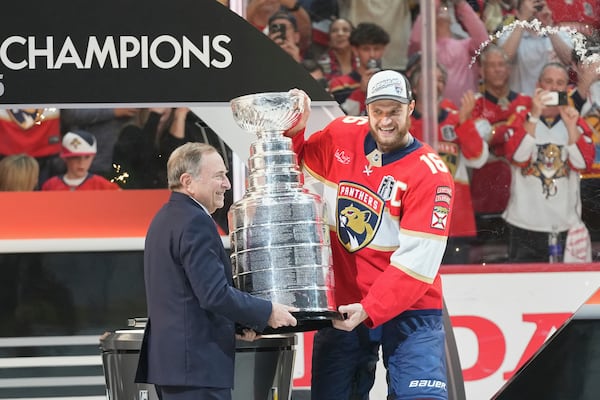 NHL commissioner Gary Bettman, left, hands the Stanley Cup to Florida Panthers captain Aleksander Barkov (16) after defeating the Edmonton Oilers in Game 6 of the NHL hockey Stanley Cup Final Tuesday, June 17, 2025, in Sunrise, Fla. (AP Photo/Lynne Sladky)