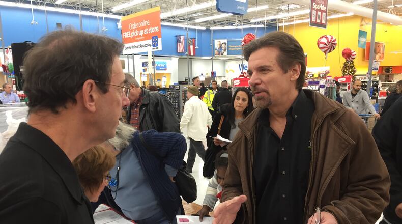 Clark Howard, at the Milton Wal-Mart December 9 for the Clark's Kids toy drive, gabs with BurgerFi franchise owner Ron Altman. CREDIT: Rodney Ho/ rho@ajc.com