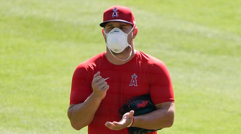 Los Angeles Angels center fielder Mike Trout (27) stands on the field wearing a face mask during a baseball practice at Angels Stadium on Friday, July 3, 2020, in Anaheim, Calif. (AP Photo/Ashley Landis)